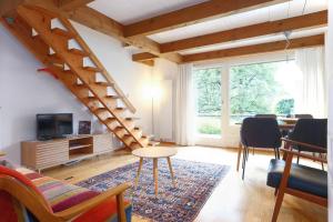 a living room with a staircase and a table and chairs at Apartment Nussbaum - GRIWA RENT AG in Grindelwald +8 photos