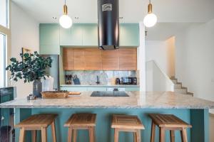 a kitchen with a counter with four stools at Enjoy Palasa Comfy Villas in Palasë