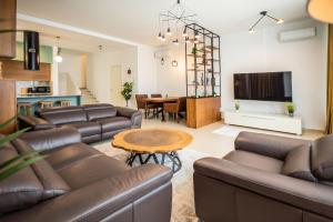 a living room with leather couches and a table at Enjoy Palasa Comfy Villas in Palasë