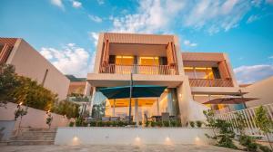 a large building with a patio and umbrella at Enjoy Palasa Comfy Villas in Palasë