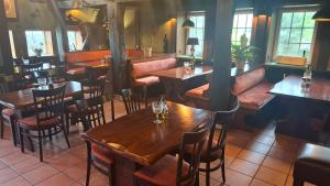 a restaurant with wooden tables and chairs at Gasthof Altes Farmhaus in Lienen