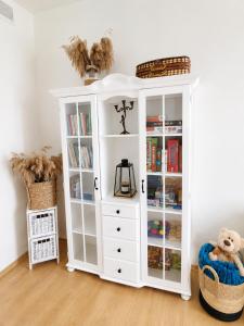 ein weißes Bücherregal mit Büchern darin in der Unterkunft Sentane in Swiętajno