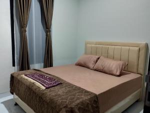 a bed in a bedroom with a pillow on it at Hasbi Homestay Syariah in Bukittinggi
