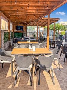 an outdoor patio with wooden tables and chairs at Solea Family Hotel & Restaurant l Free Parking in Ravda