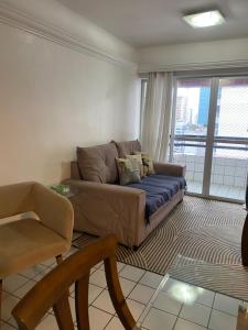 a living room with a couch and a chair at Apto com localização privilegiada e piscina - Charmoso e completo in Recife