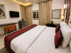 a hotel room with a large bed and a desk at Smarthome Hotel in Benin City