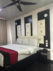 a bedroom with a large bed with a ceiling fan at Smarthome Hotel in Benin City