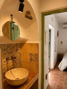 a bathroom with a stone sink and a mirror at Encanto Guesthouse in Canillas de Aceituno