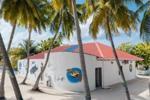 a building with palm trees in front of it at Feeali Buddies Inn in Maldive Islands