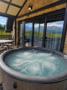 a jacuzzi tub in a building with windows at Mountain Whisper in Žabljak