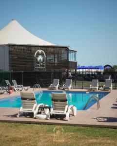 a group of lounge chairs and a swimming pool at Mad Sea Beach Hotel in Şile