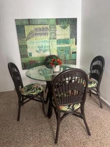 a glass table with two chairs and a table with a plant at Modern Apartment in Las Piedras in Las Piedras +2 photos