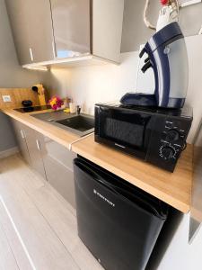 a kitchen with a microwave on a counter at Reflet Marin - Studio Village Soleil in Le Gosier