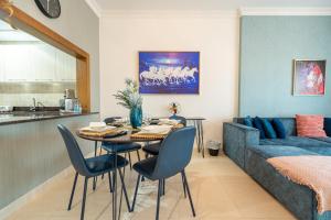 a living room with a table and chairs and a bed at Yas Island 1BR - Coastal Blue Haven in Abu Dhabi