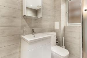 ein Badezimmer mit einem weißen Waschbecken und einer Toilette in der Unterkunft Bright, Spacious Double Room in a Modern Flat in Edmonton