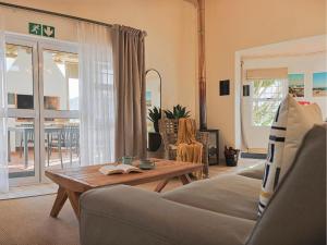 a living room with a couch and a table at Fijnbosch Self-Catering Units in Jacobs Bay