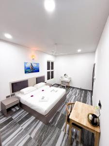 a bedroom with a large bed and a table at Feeali Buddies Inn in Maldive Islands