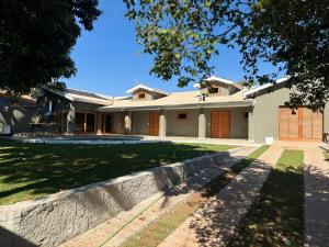 a large white house with a brick wall at Charming house in countryside in Brotas