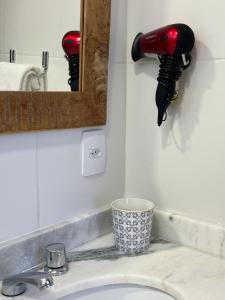 a blow dryer on a wall above a bathroom sink at Jardim Secreto - Itaipava in Itaipava +81 photos