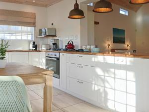 a kitchen with white cabinets and a wooden table at Fijnbosch Self-Catering Units in Jacobs Bay