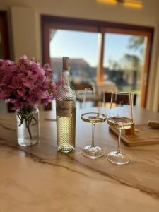 a bottle of wine and two glasses on a table at Charming house in countryside in Brotas