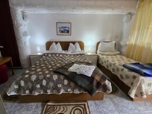 a bedroom with two beds with towels on them at Apartament de vacanta Criss in Buşteni