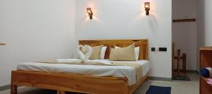 a bedroom with a bed with white sheets and towels at Hungry Wave in Arugam Bay