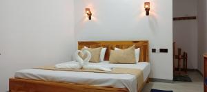 a bedroom with a bed with two towels on it at Hungry Wave in Arugam Bay