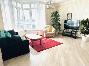a living room with a couch and a tv at Apartments with Dnipro view in Kyiv