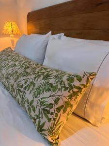 a bed with a green and white blanket on it at Jardim Secreto - Itaipava in Itaipava
