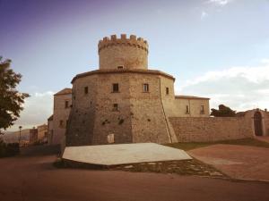 a building with a tower on the side of a road at casa vacanza Lu Murajon in Dogliola