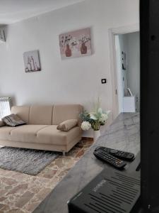 a living room with a couch and a table with a laptop at casa vacanza Lu Murajon in Dogliola
