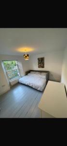 a bedroom with a bed and a table in it at Strand Retreat in Tintagel