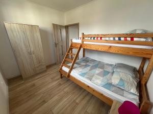 two bunk beds in a room with wooden floors at Sofia Domki Wakacyjne Dwupoziomowe in Jarosławiec +97 photos