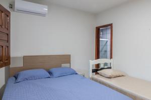a bedroom with a blue bed and a window at Recanto do mar in Ilhéus