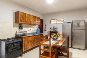 a kitchen with a table and a stainless steel refrigerator at Recanto do mar in Ilhéus