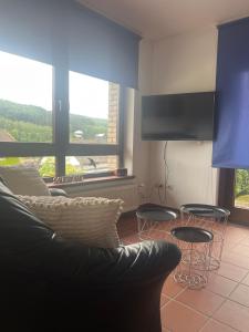 a living room with a couch and two tables and a tv at Fernblick Oase in Meschede
