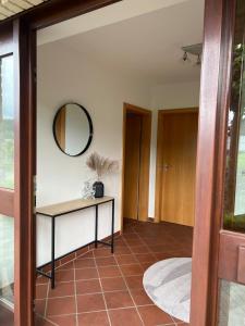 a hallway with a table and a mirror at Fernblick Oase in Meschede