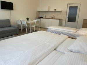 a room with three beds and a table and a kitchen at Hotel Koruna in Roudnice nad Labem
