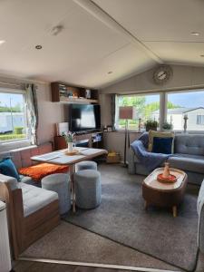 a living room with a couch and a table at Seton Sands Holiday Village Luxury 61 Muirfield Near Edinburgh Free WiFi in Port Seton
