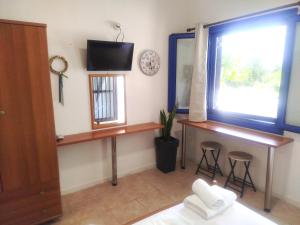 a room with two desks and a window and a tv at Sarantakis Apartments in Agios Andreas