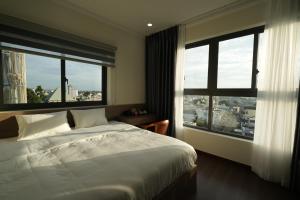 a bedroom with a bed and two large windows at Olivia Hotel in Ấp Thành +61 photos