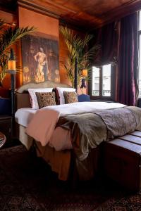 a bedroom with a large bed with a painting on the wall at Guesthouse Nights by Morpheus in Antwerp