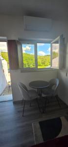 a room with a table and chairs and windows at Residencial Hospedaria Vale do Rodo in Peso da Régua