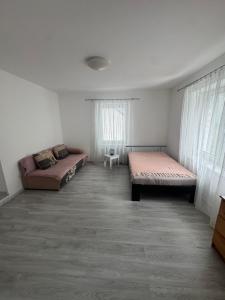 a room with two beds and a couch in it at Pod Kyčarou in Čabalovce