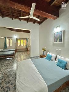 a bedroom with a large bed with a ceiling fan at The Thota Mane by evaddo stays in Sakleshpur