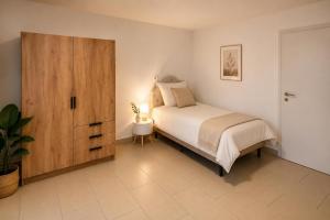 a bedroom with a bed and a wooden cabinet at Arcade Apartment Bad Oldesloe in Bad Oldesloe