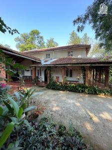 a house with a driveway in front of it at The Thota Mane by evaddo stays in Sakleshpur