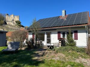 a house with solar panels on the roof with a castle at Ferienhaus Bibernest in Münsingen