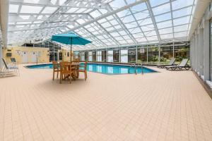 a patio with a table and an umbrella next to a pool at Quality Inn and Conference Centre in Pembroke